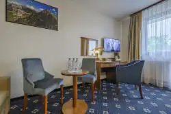 Hotelværelse med et lille bord og skrivebord